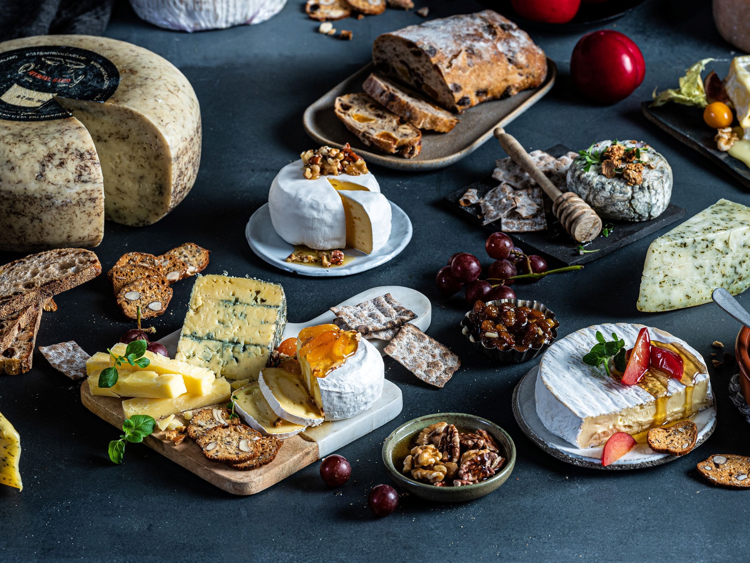 Et utvalg av ulike oster, kjeks, frukt og sjokolade på et bord, klar for helgekos.