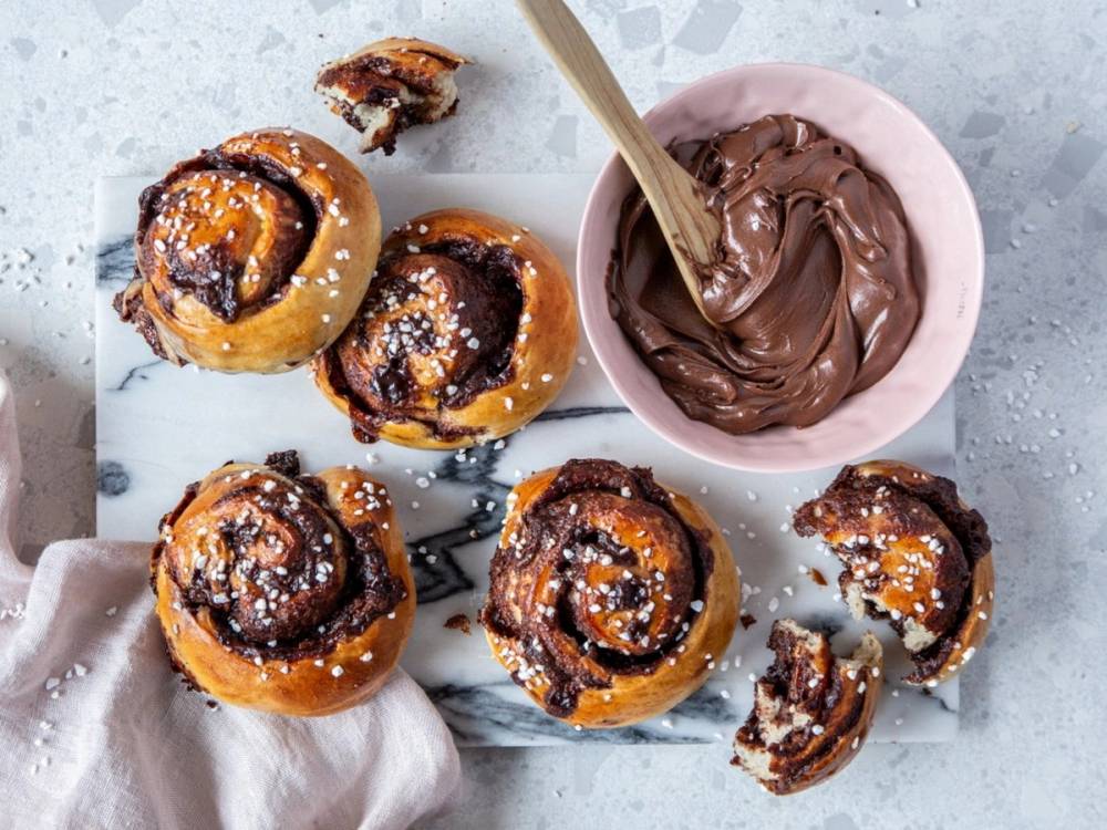 Nugattisnurrer med sjokoladefyll og melis på toppen, sammen med en skål med smeltet sjokolade