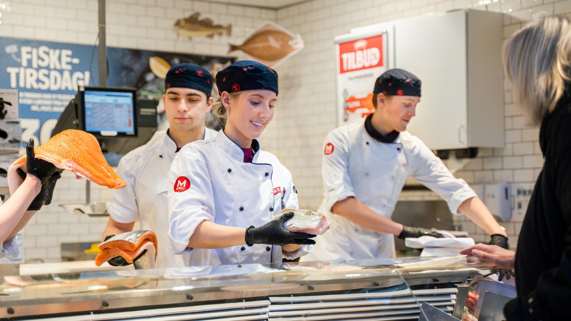 Tre matarbeidere bak ferskvaredisken.