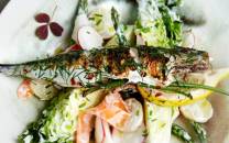 Grillet makrell med sitron og grønnsaker på en tallerken.