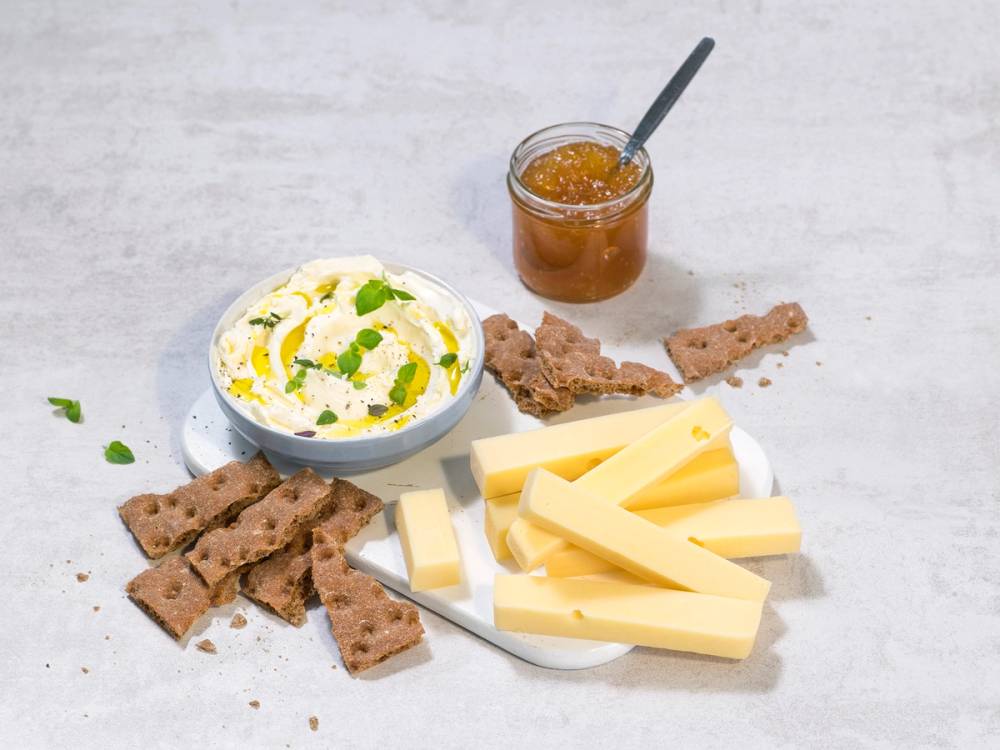 Ostedipp med hverdagsost, serveres med kjeks og ostestykker på et hvitt bord