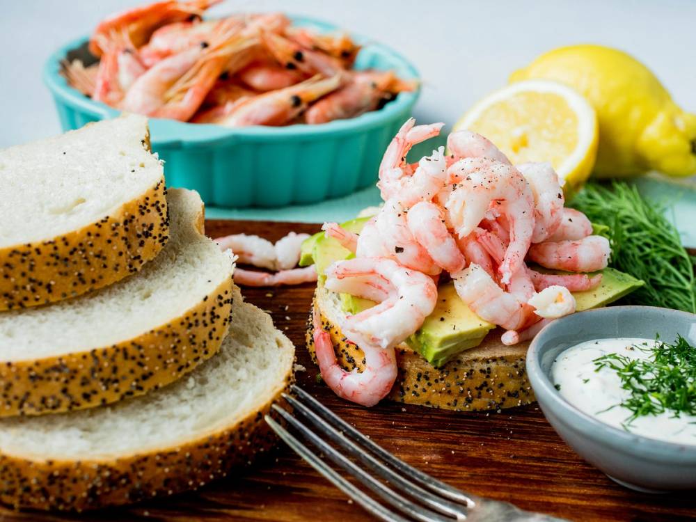 Rekesalat med sitronbiter, brødskiver og dipp på et fat, klar til rekekalas.