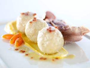 Tre kokte kuler med saus og en skive kjøtt på en tallerken