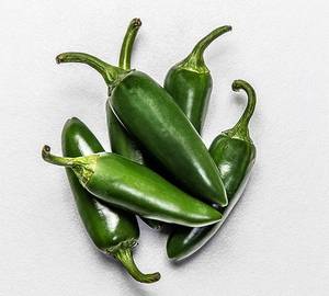 Fem grønne jalapeño-chilipepper på en hvit bakgrunn