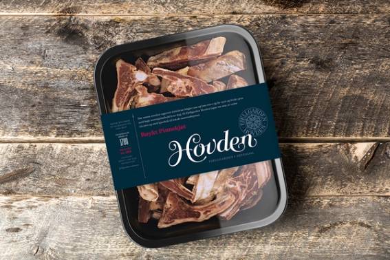 Pakke med kjøttdeig eller lignende kjøttprodukter på en treflate, med en blå etikett som sier 'Hovden'.