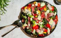 En biffsalat med grønnsaker og spicy avokadodressing i en svart bolle