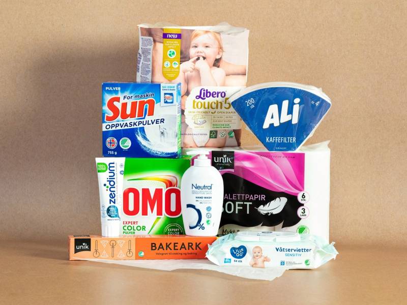 En rekke dagligvarer som toalettpapir, oppvaskpulver, kjeks, og medisiner er plassert på et bord.