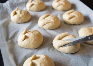 Hjemmelagde påskegodteriboller som er formet og ligger på et bakepapir, med en kniv som former en av bollene.