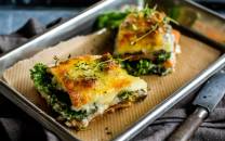 Grønnsakslasagne med aubergine, søtpotet og grønnkål, ser gyllen og fristende ut på en bakeplate.