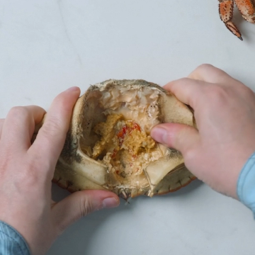 Person som åpner en kyllingkrok med hendene, viser innsiden av den.