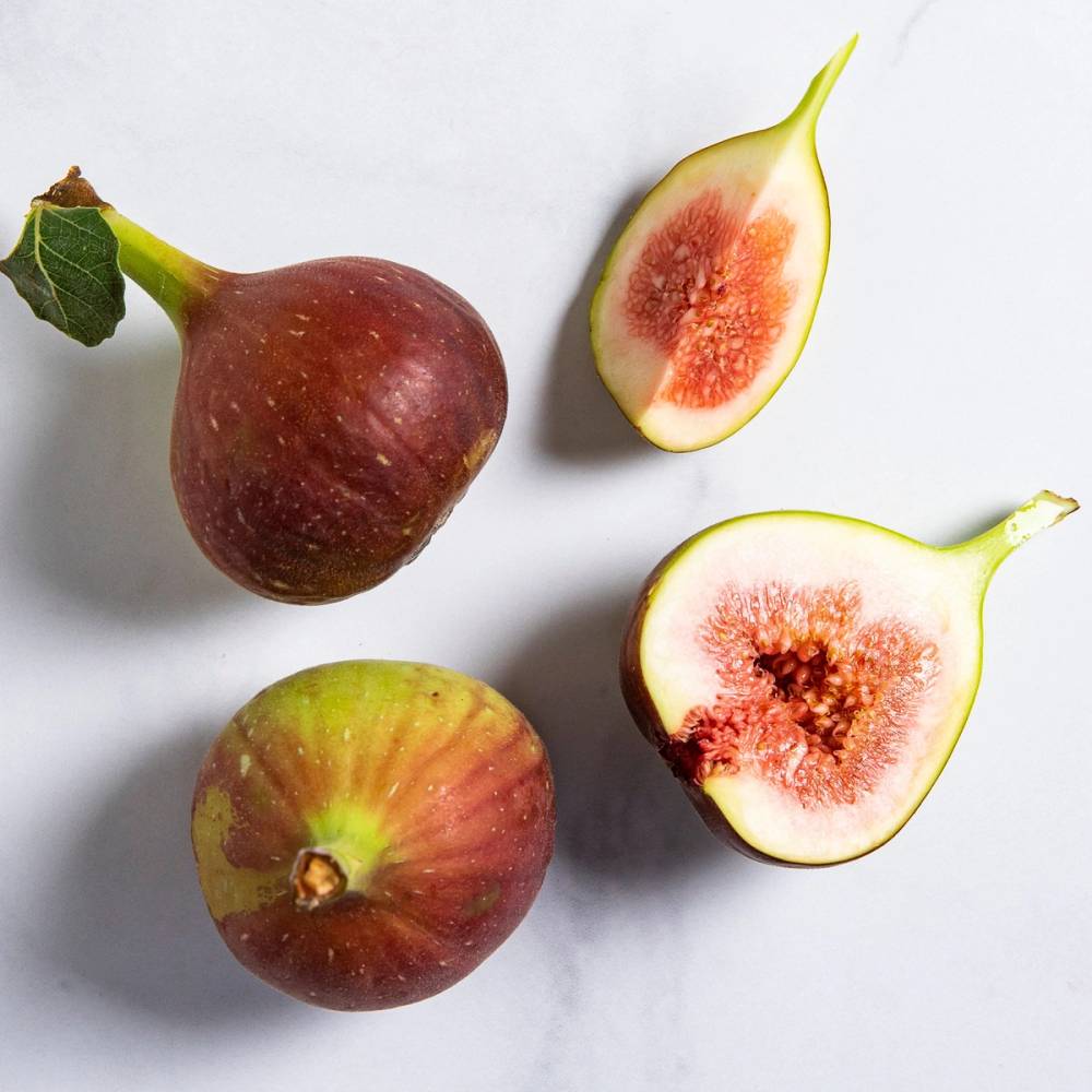 To hele fiken og to halverte fiken med rosa innmat på en hvit bakgrunn.