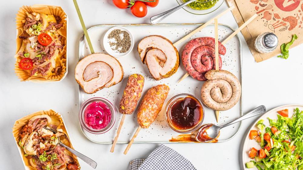 Ulike typer av iskrem og sorbet på en hvit bakgrunn, med noen småkaker og frukt rundt.