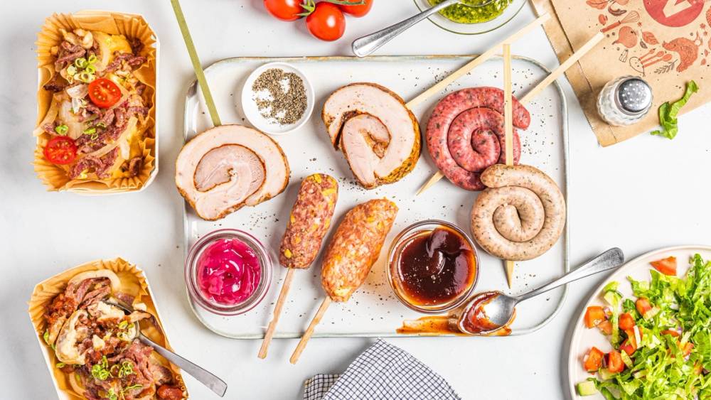 Ulike typer av iskrem og sorbet på en hvit bakgrunn, med noen småkaker og frukt rundt.