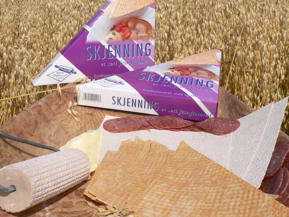 Ulike typer av kjøkkenpapir og en pakke med skinnbehandling på et bord i et åkerlandskap.