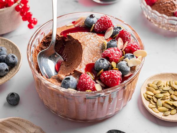 Sjokolade mousse pyntet med bær og mandler i en glassbolle