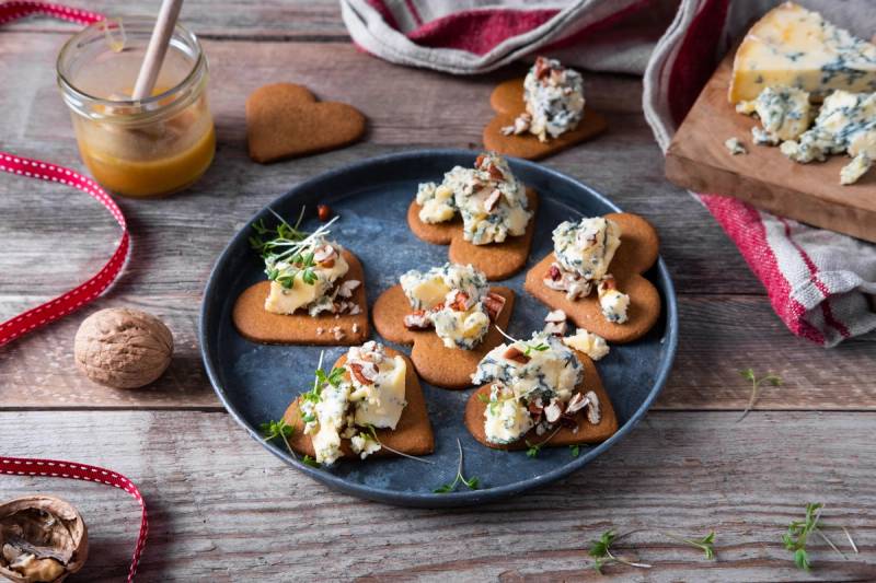 Pepperkaker med stilen pyntet med hvit krem og små dekorasjoner på et rundt fat.