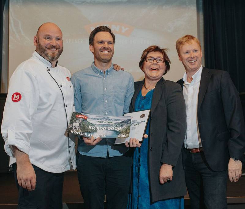 En gruppe mennesker står på scenen under en prisutdeling, og en av dem holder et stort sjekk med teksten 'Matskatt vinner 2018'.