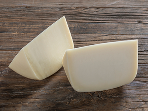 To hvite ostestykker på en treplate.