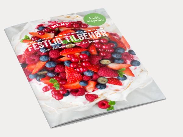 En festlig dekorert kake med bær og blomster på et hvitt fat, klar til feiring i mai 2015.