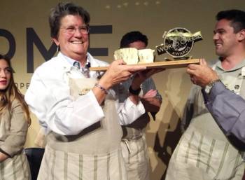 En gruppe personer feirer med et trofé etter å ha vunnet oste-VM 2019, med fokus på en person som holder trofeet.