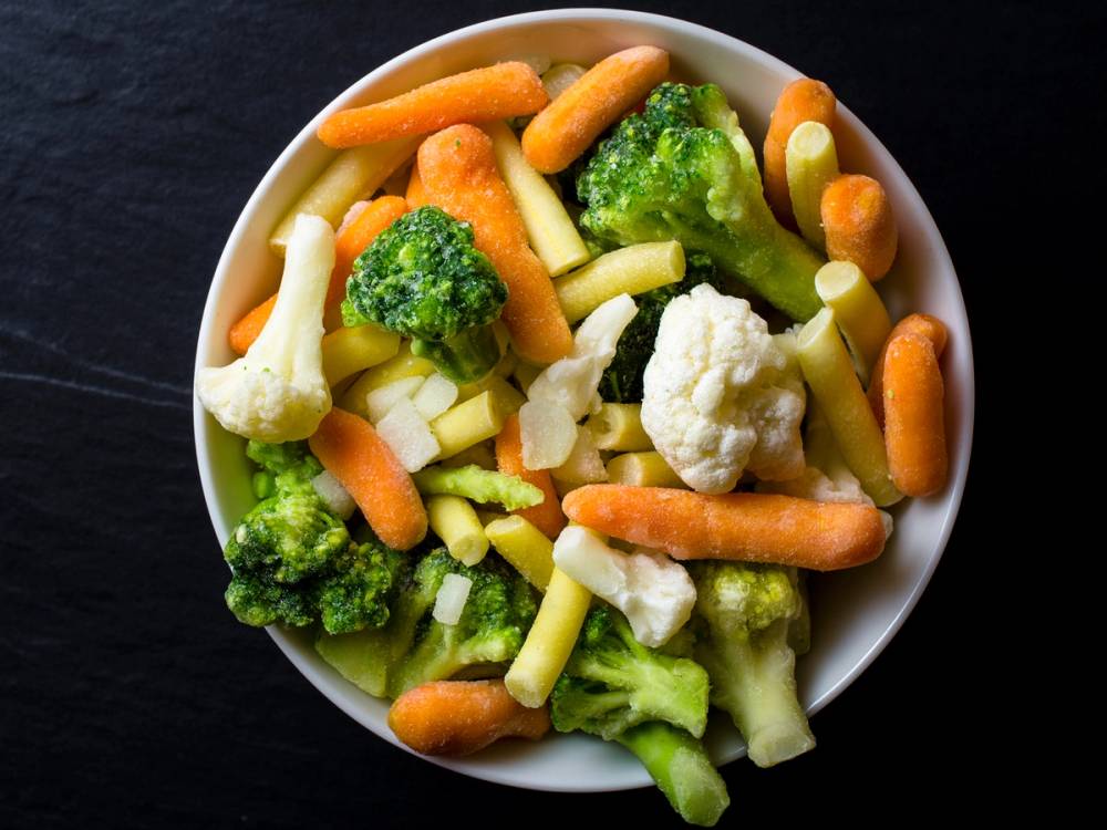 Blandet fryste grønnsaker i en bolle, klare til bruk og tilbereding.