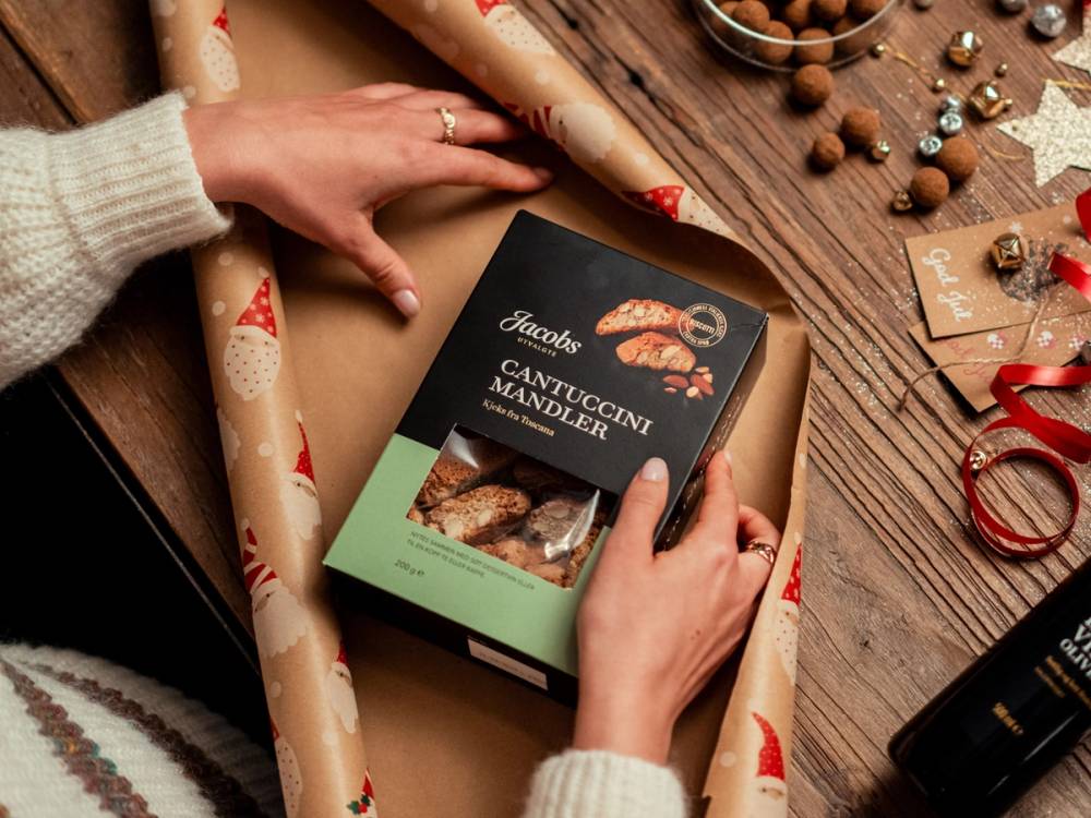 En eske med Jacobs Cantuccini pakkes inn i julepapir.