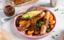 En tallerken med pølser, potetmos, gulrøtter og brunsaus, typisk for ukens middag bangers and mash.