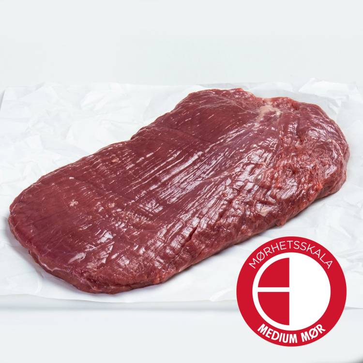 En rå Angus flanksteak på en hvit overflate med Nærhetsskala-merke for medium mørk kjøttfarge.