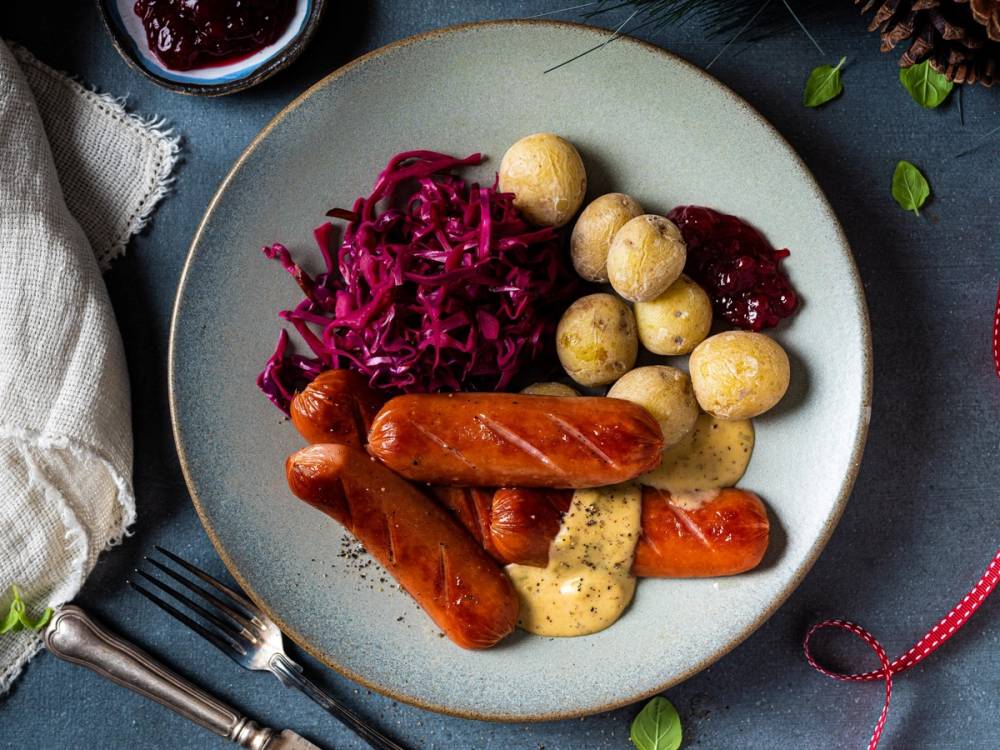 En tallerken med pølser, kokte poteter, rødkål og gulrøtter, ser ut som en typisk ukesmiddag.