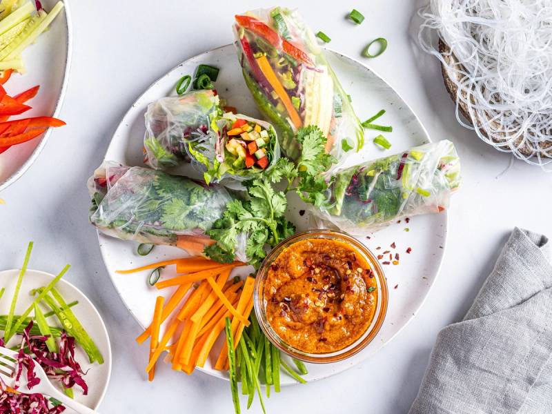 Vegetariske sommerruller med grønnsaker og urter, servert med en dipp i en liten skål