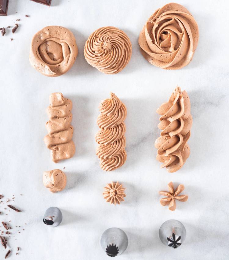 Ulike typer av sjokolade- og karamellkrem i ulike former og størrelser på en hvit bakgrunn.