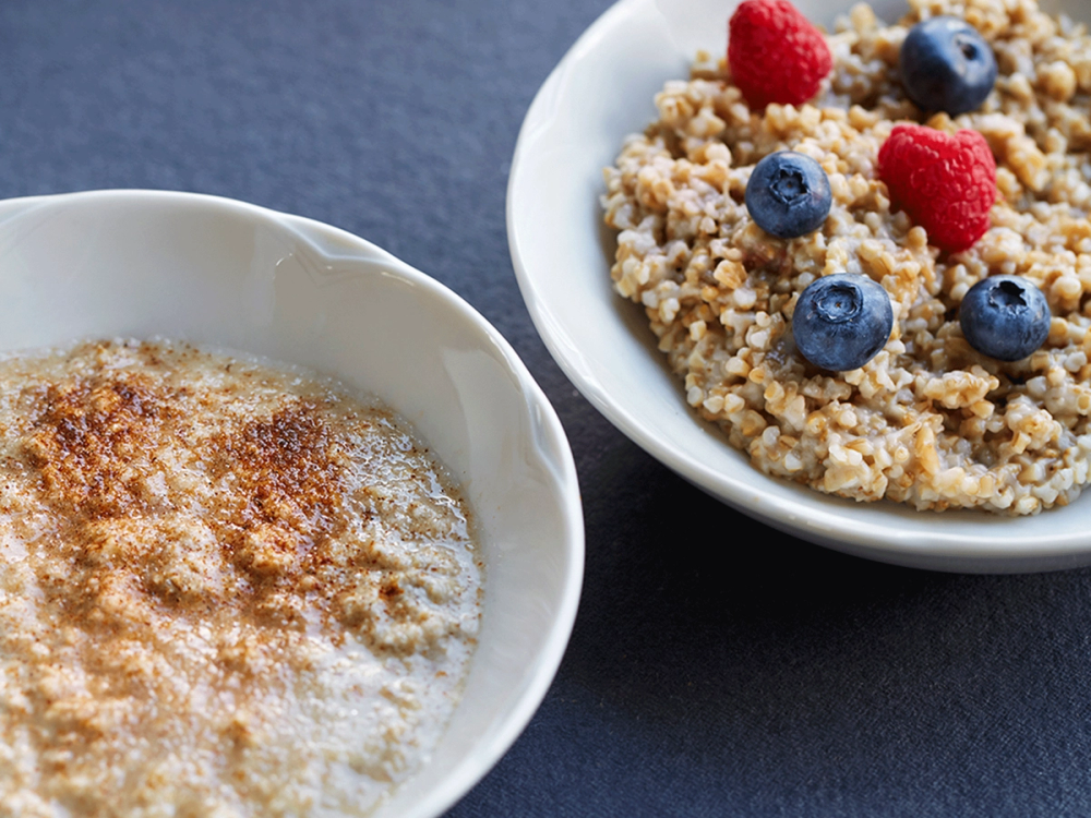 Havregryn og havregrøt med bær på to hvite tallerkener