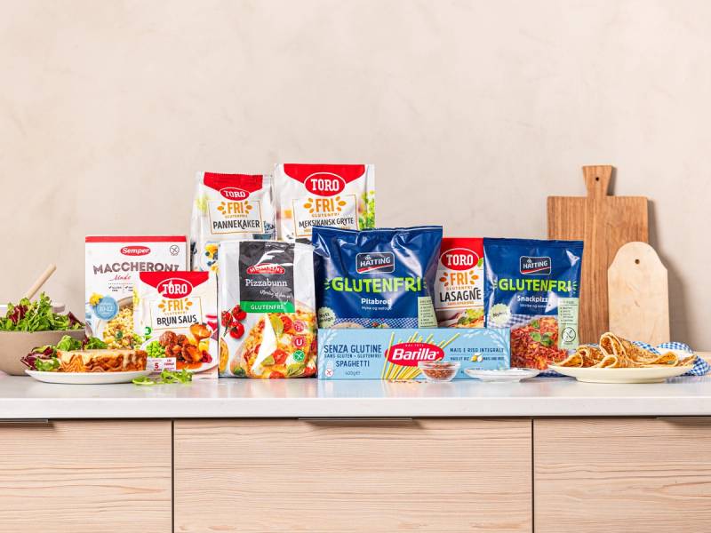 Ulike matvarer og pakninger på et kjøkkenbord, inkludert glutenfrie produkter og en pakning med merket 'Fri For Miljø'.