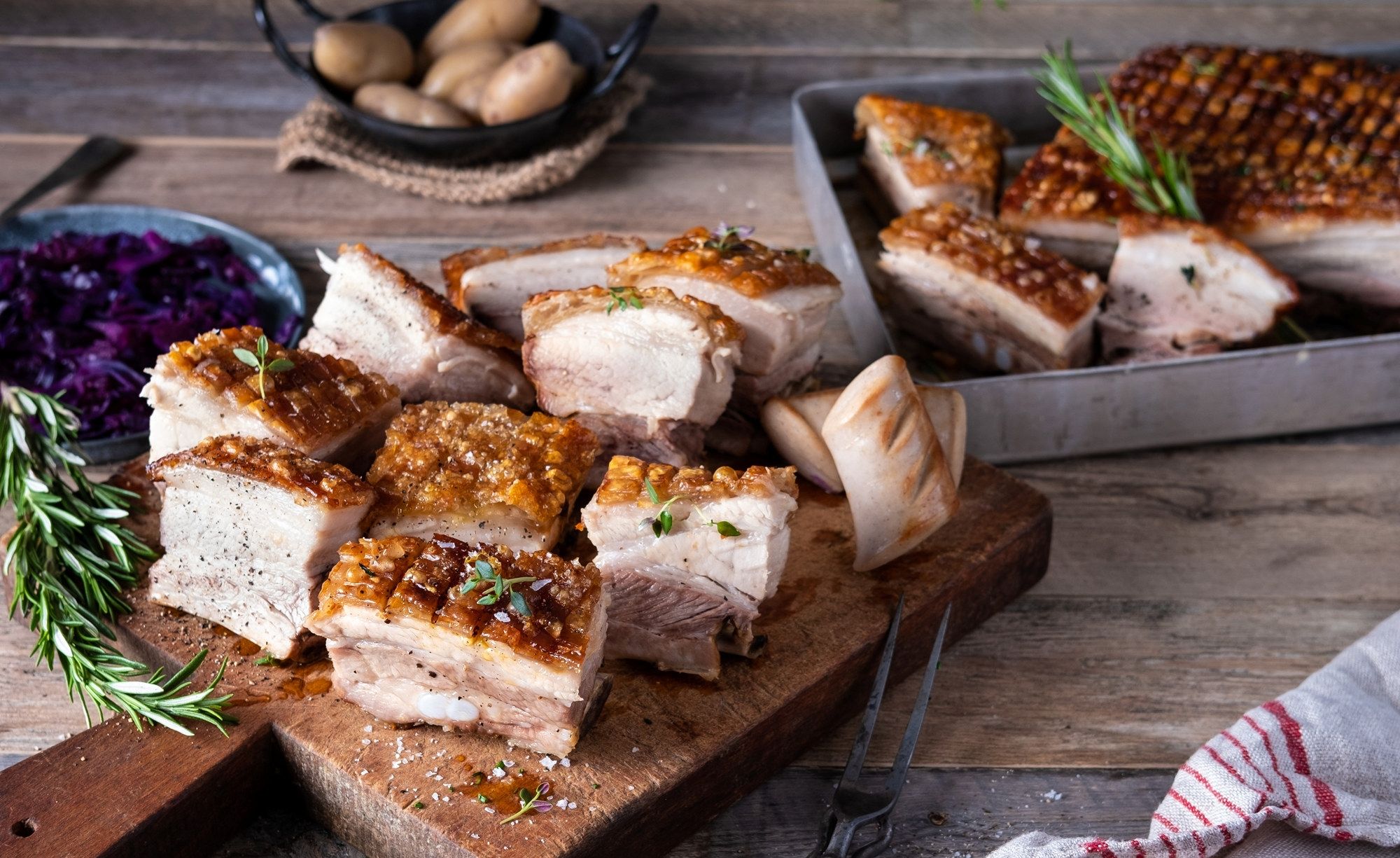 Ribbe med sprø svor og tilbehør på et serveringsfat, klar til å bli servert.