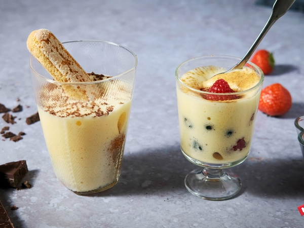 To glass med eggedosis, en med kjeks og en med bær, på et bord