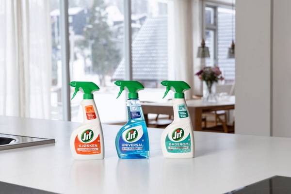 Tre sprayflasker med Jif rengjøringsprodukter står på et kjøkkenbord foran store vinduer.