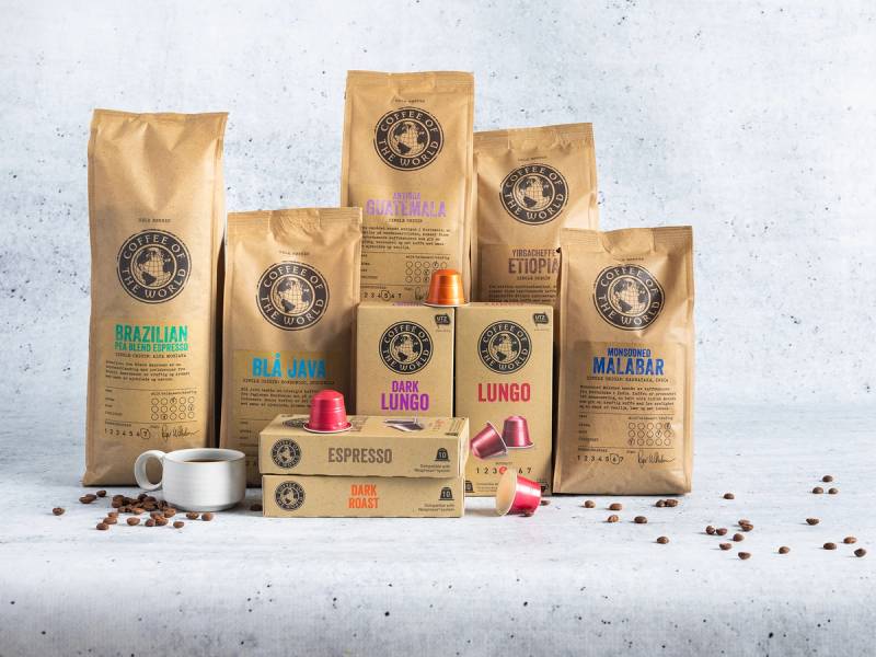 Ulike eske- og posepakker med kaffebønner og kaffekapsler på en hvit bakgrunn, med noen kaffebønner spredt rundt.