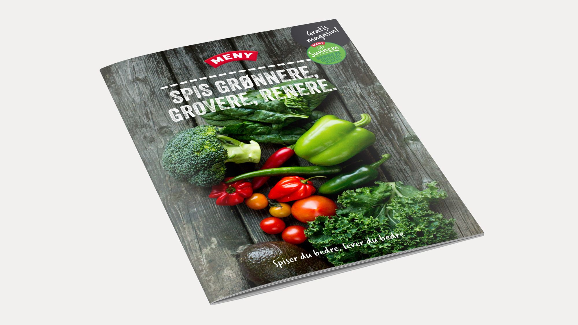 Forside av en bok eller katalog med bilder av grønnsaker som paprika, tomater og brokkoli, med tittelen 'Spis grønnere, grovere, mer grønt' på forsiden.