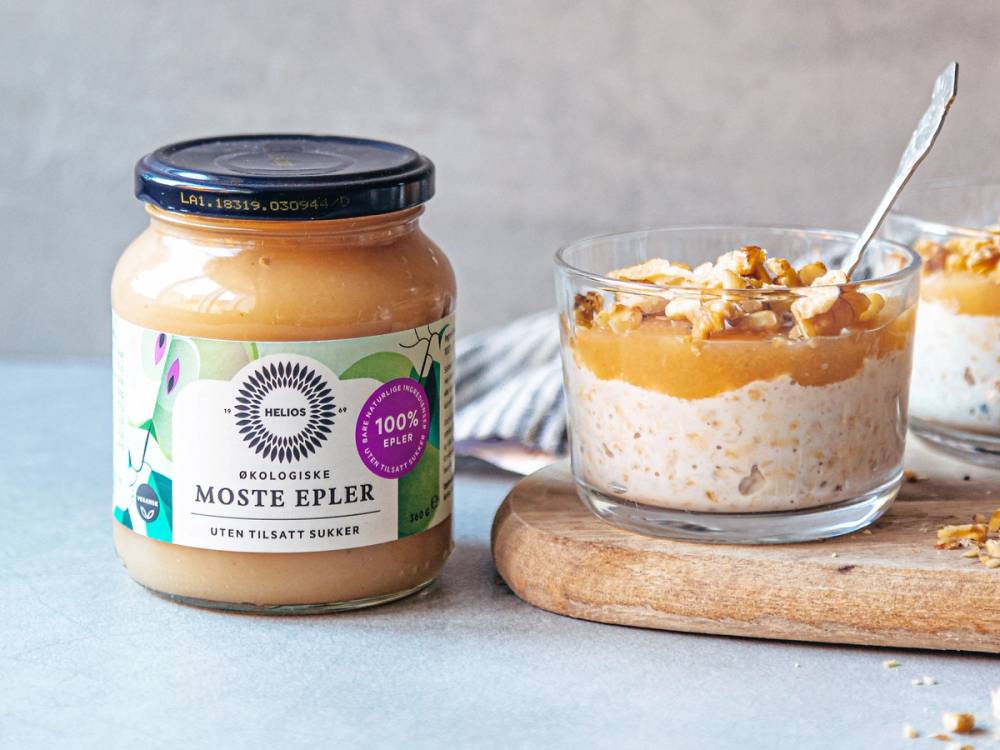 Kjøleskapsgrøt i glass med skje, plassert på en treplate, ved siden av et glass med tilsvarende grøt.