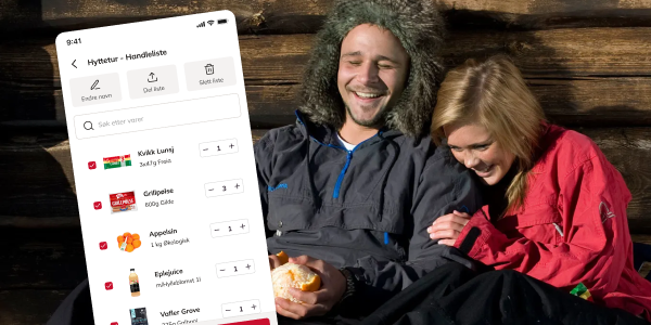 To personer sitter i en hyttevegg, en av dem holder en mobiltelefon med en matbestillingsapp åpen, og de ser ut til å ha en hyggelig stund sammen.