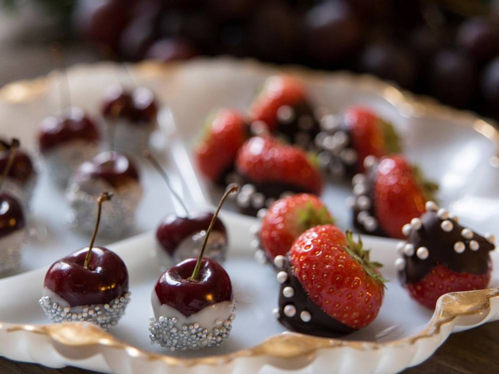 Ferske jordbær og sjokoladekledde kirsebær på et fat