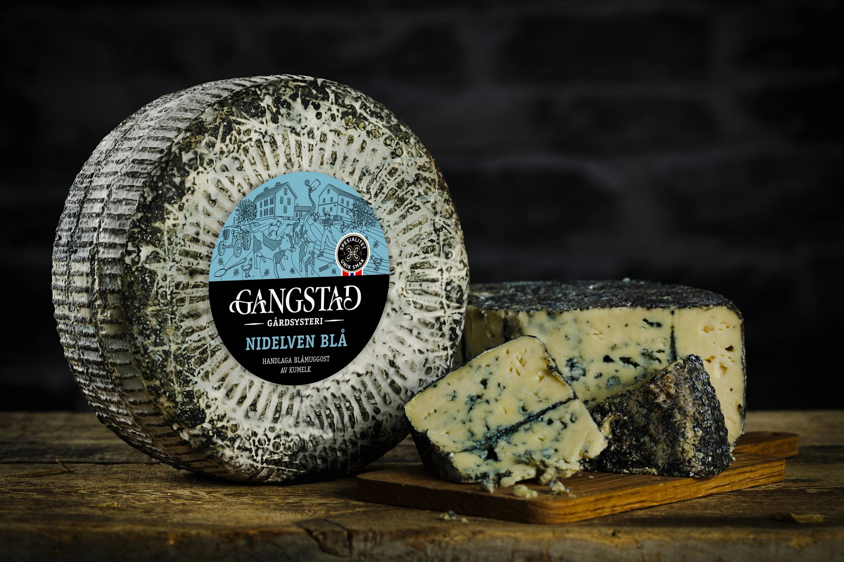 Et hjulkost med blåmuggost og noen skiver blåmuggost ved siden av, med en mørk bakgrunn.