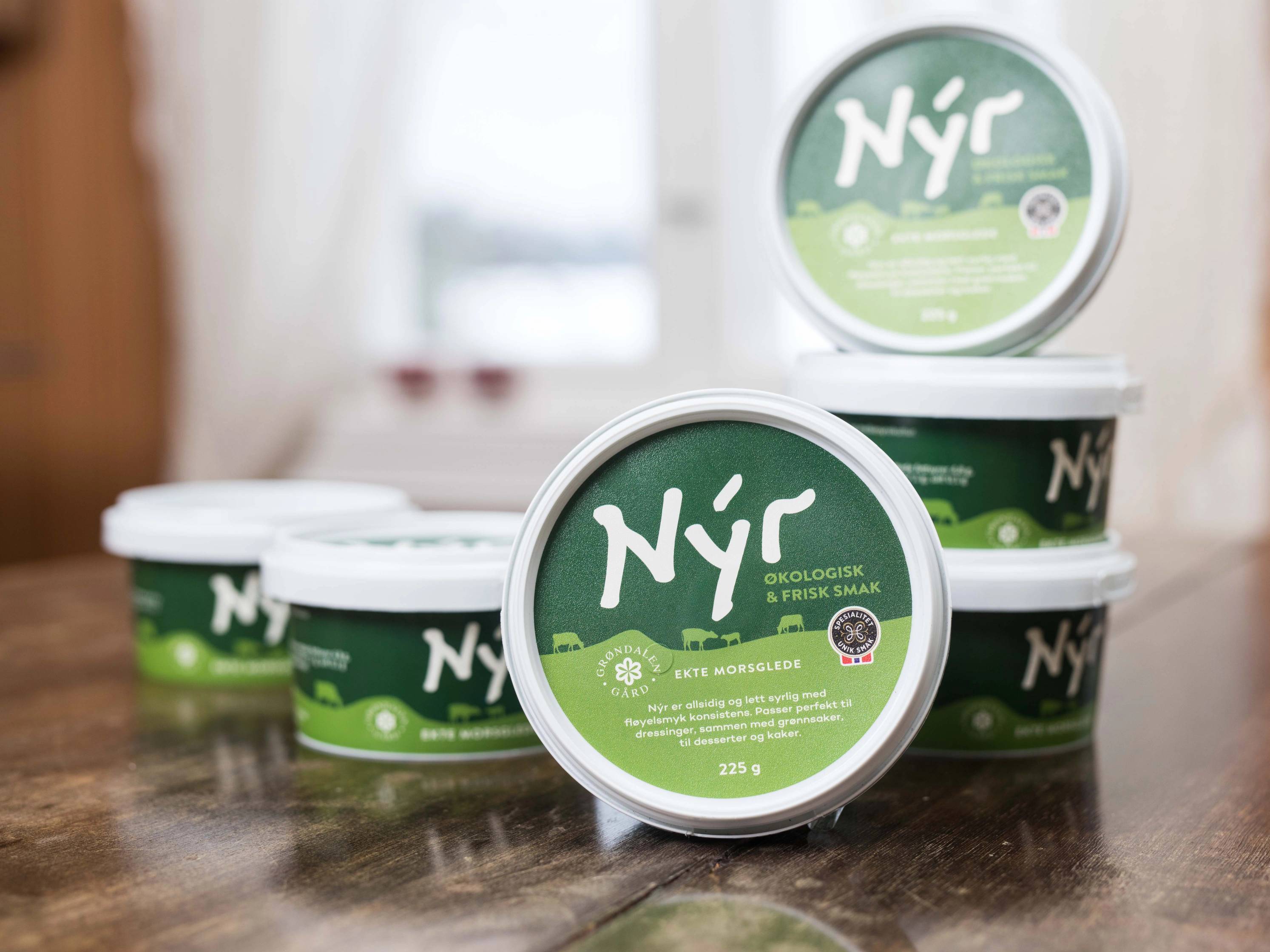 Fire små grønne og hvite plastbegre med etiketter som sier 'Nyr' står på et bord.