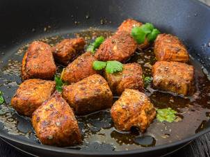 Friterte fisketacobiter stekt i panne med grønne urter som koriander eller persille.
