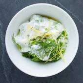 Persille og andre urter i en hvit bolle med en kremet saus eller dip