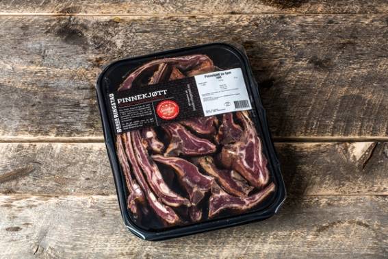 Pakke med rått kjøtt, sannsynligvis til jul, på en treoverflate.