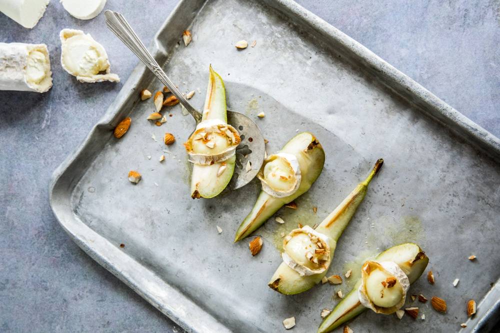 Ferske geitostkuler med nøtter på en metallfat, klar til servering.