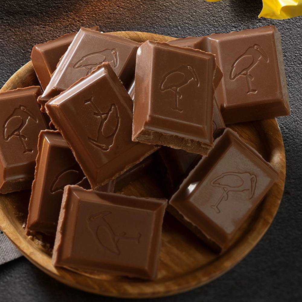 Melkesjokoladestykker i en skål, med et bilde av en is på hver sjokoladebit