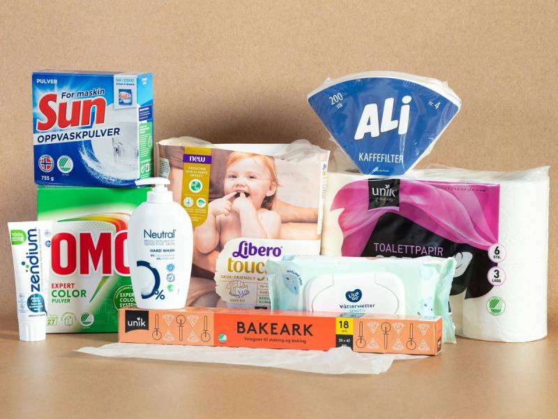 Ulike svanemerkede husholdningsprodukter som vaskepulver, toalettpapir og såpe på et bord.