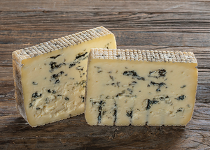 To stykker blåmuggost med blå muggsporer på en treplate, klar til servering.